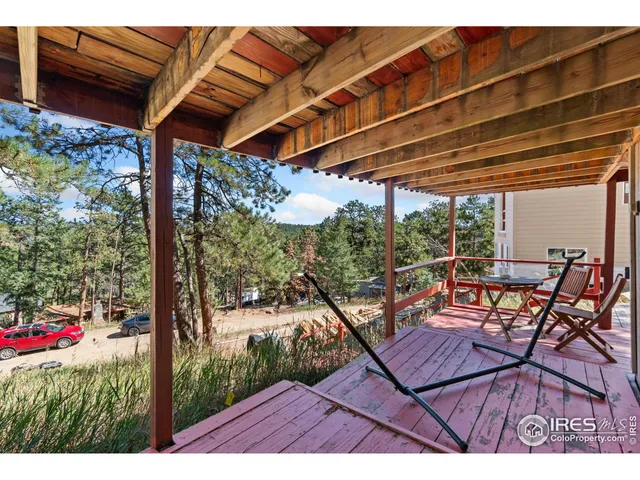 a view of a patio with table and chairs under an umbrella with a small yard
