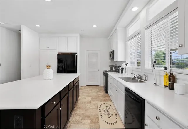 a kitchen with stainless steel appliances a sink stove refrigerator and cabinets