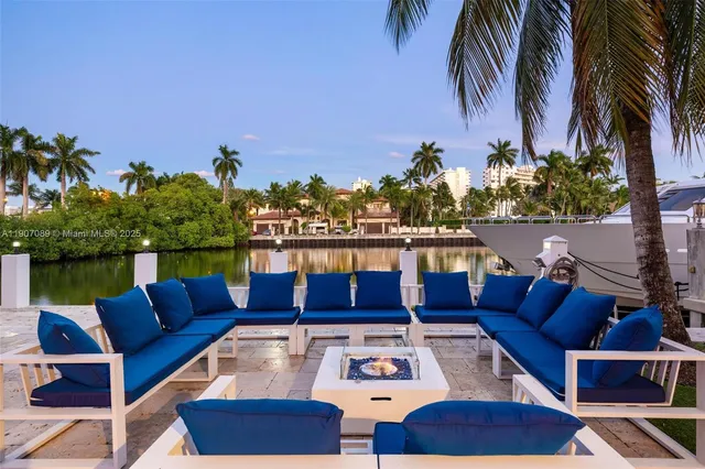 a view of a patio with couches table and chairs potted plants and palm tree