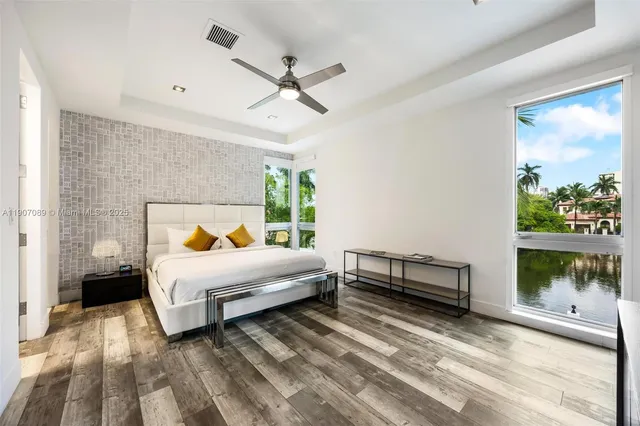 a spacious bedroom with a large bed and a wooden floor