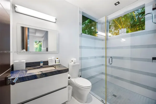 a bathroom with a double vanity sink a large mirror and bathtub