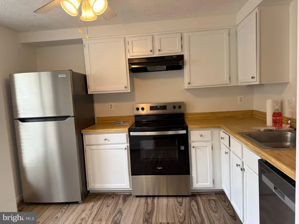 a kitchen with stainless steel appliances granite countertop a refrigerator sink and stove