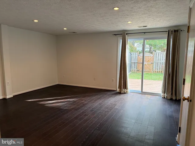 an empty room with wooden floor and sliding window