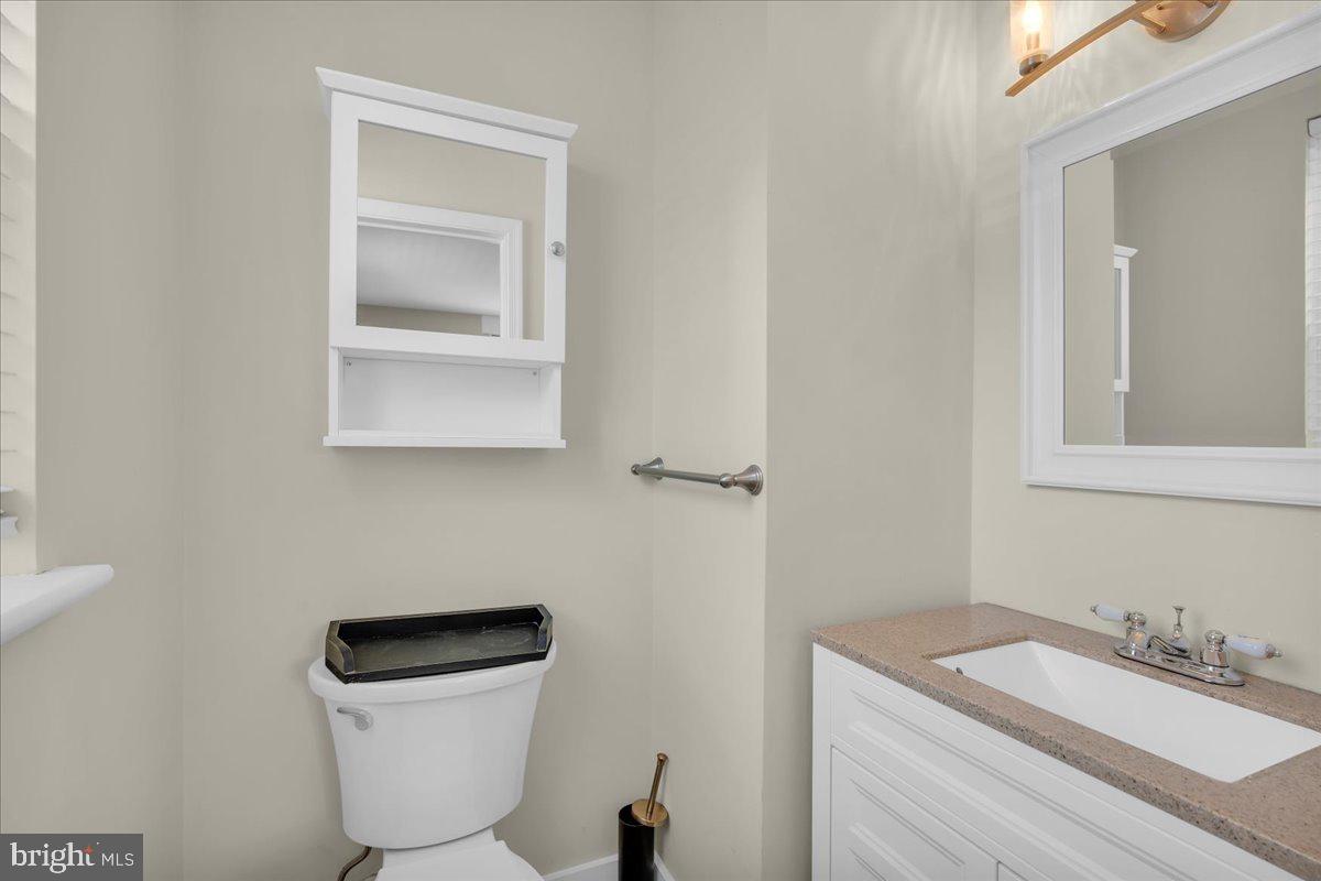 217 South Main Street Elmer, NJ 08318 - Photo 17 of 25 a bathroom with a toilet a sink and mirror