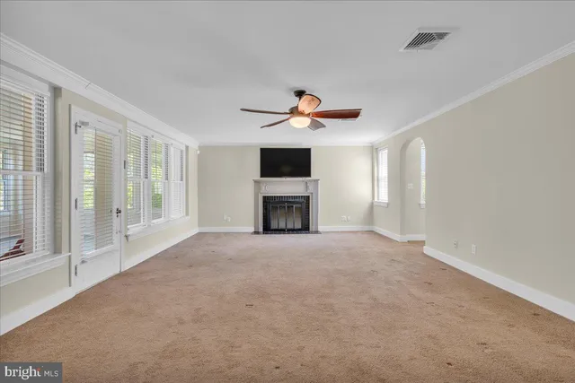 a view of an empty room with a fireplace and a window