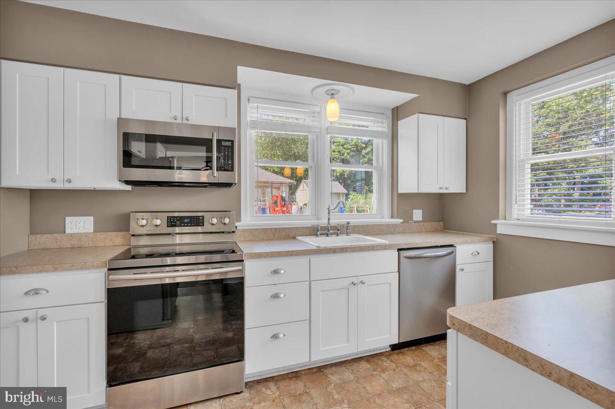 217 South Main Street Elmer, NJ 08318 - Photo 7 of 25 a kitchen with cabinets appliances a sink and a window