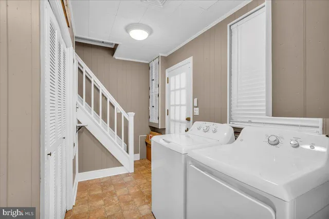 a view of washer and dryer with bathroom in the background