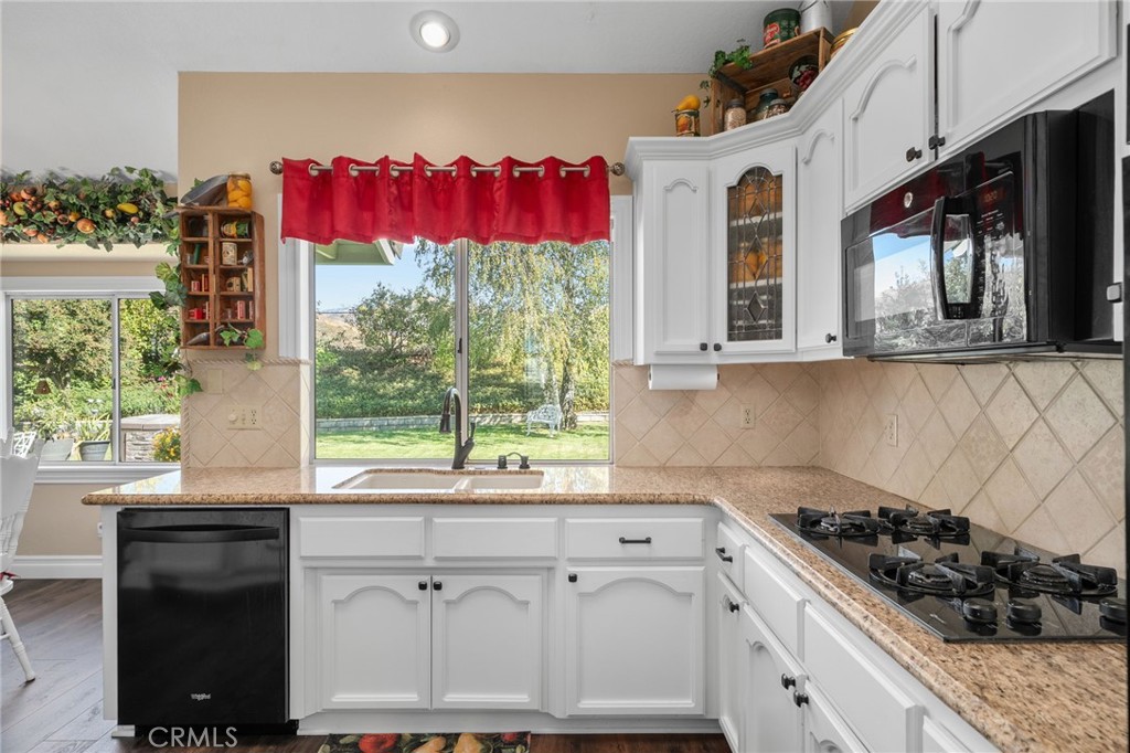 10684 Lakeview Road Yucaipa, CA 92399 - Photo 19 of 63 a kitchen with granite countertop a stove a sink and a window