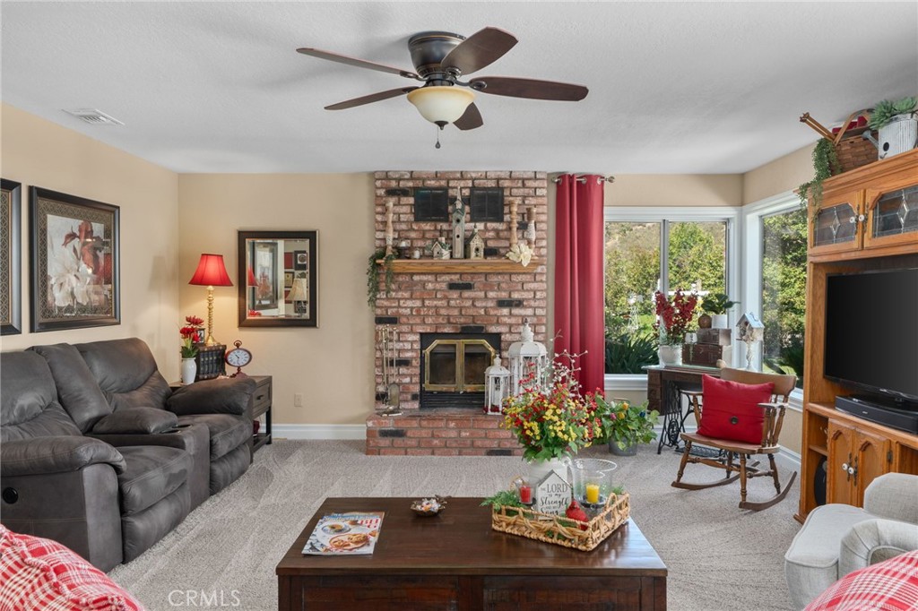 10684 Lakeview Road Yucaipa, CA 92399 - Photo 25 of 63 a living room with furniture a fireplace and a flat screen tv