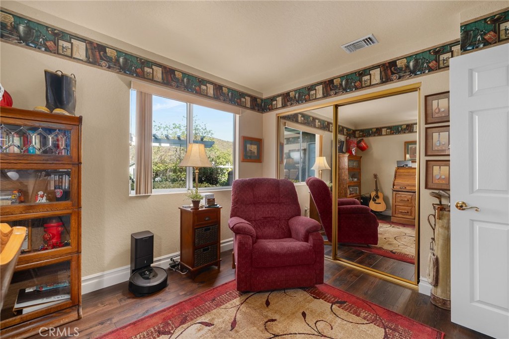 10684 Lakeview Road Yucaipa, CA 92399 - Photo 32 of 63 a living room with furniture a bookshelf and a window