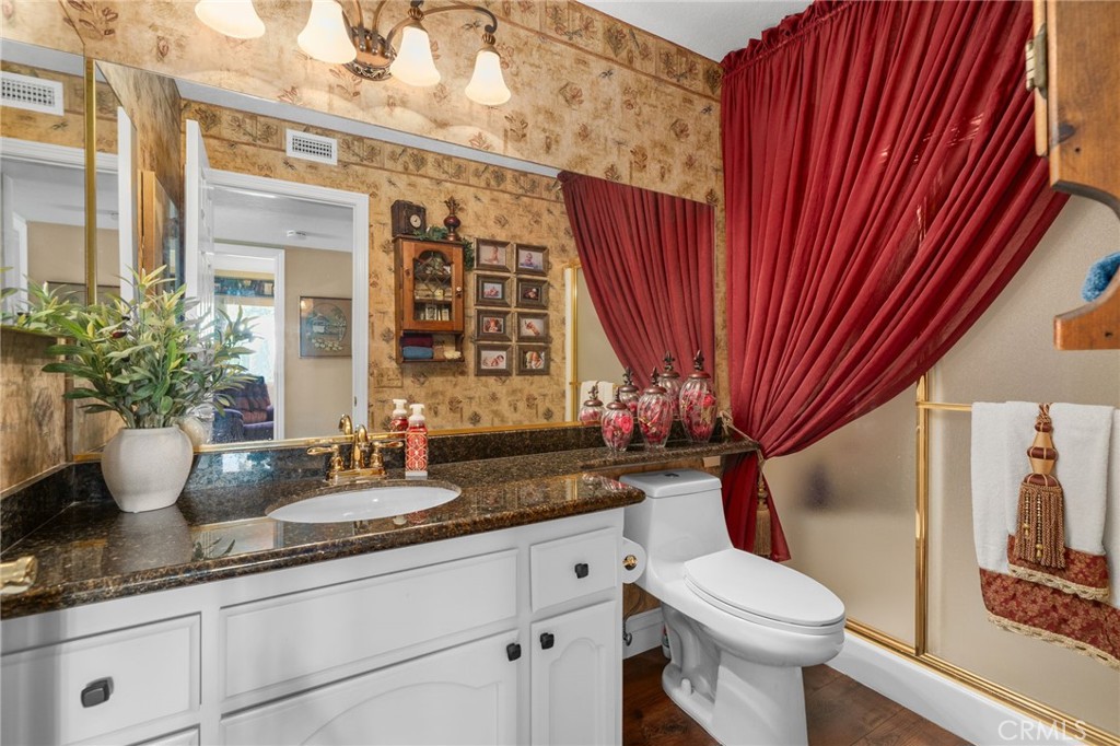 10684 Lakeview Road Yucaipa, CA 92399 - Photo 34 of 63 a bathroom with a granite countertop sink a toilet and shower
