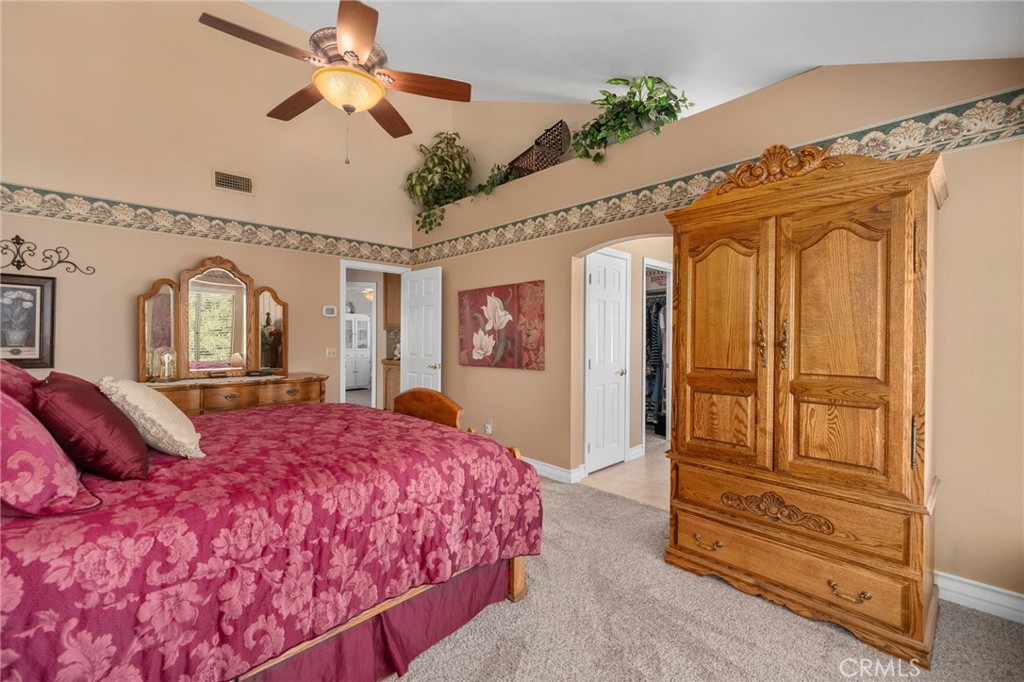 10684 Lakeview Road Yucaipa, CA 92399 - Photo 39 of 63 a bedroom with a large bed a chandelier and dresser