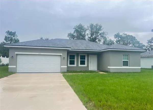front view of a house with a yard and a garage