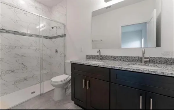 a bathroom with a granite countertop bathtub shower sink and vanity