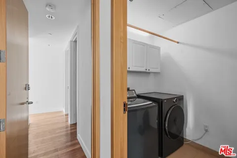 a view of a storage and utility room with wooden floor
