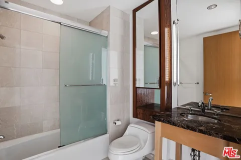 a bathroom with a granite countertop sink toilet and shower