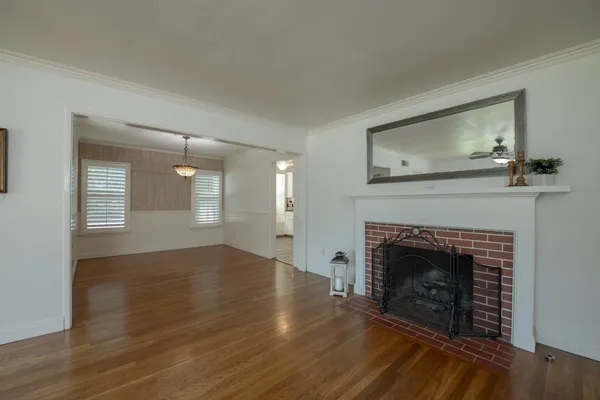 a view of empty room with wooden floor and fireplace