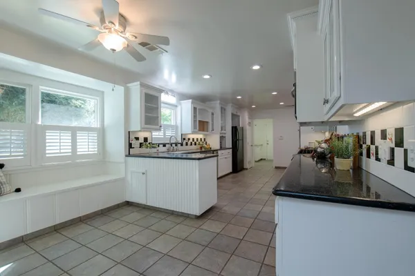a large white kitchen with a large window
