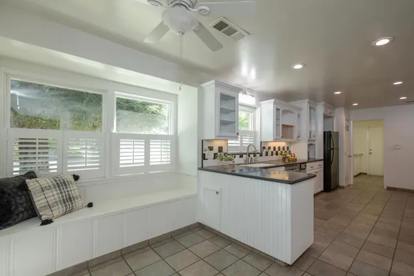 a large white kitchen with a large window