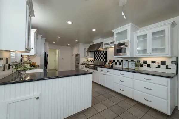 a kitchen with granite countertop white cabinets and white appliances
