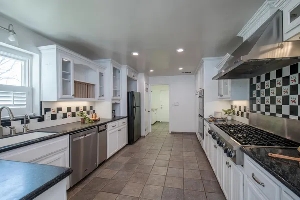 a kitchen with stainless steel appliances a sink stove and cabinets