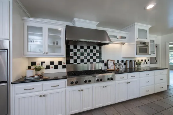 a kitchen with granite countertop a sink and cabinets