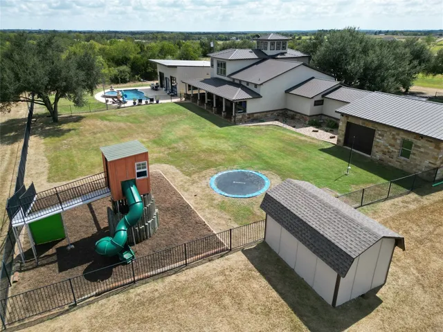 an aerial view of a house with swimming pool garden and patio