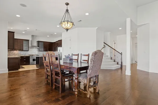 a view of a dining room and livingroom with furniture wooden floor a chandelier