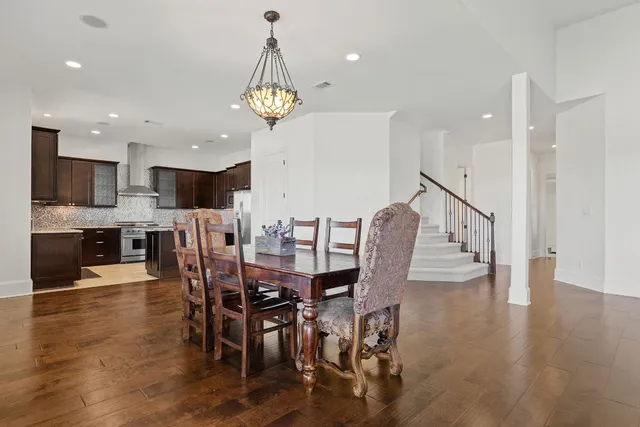 a view of a dining room and livingroom with furniture wooden floor a chandelier