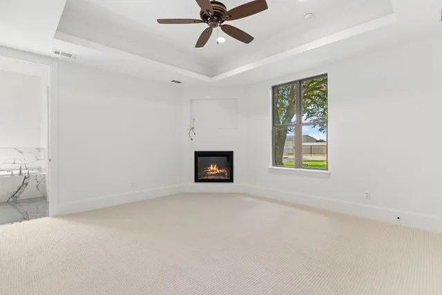an empty room with windows and ceiling fan