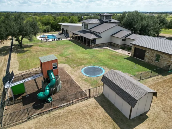 an aerial view of a house with swimming pool garden and patio