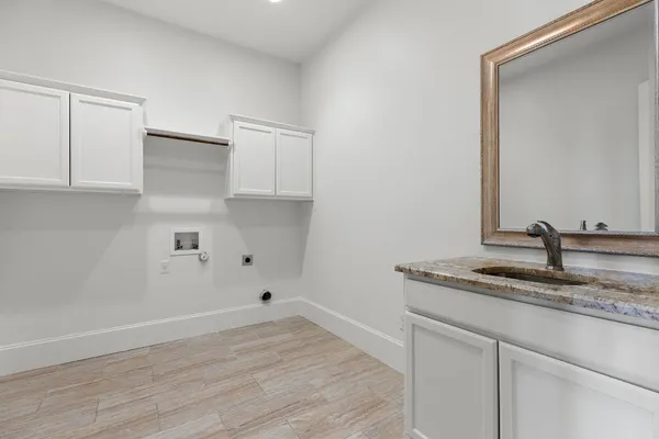 a kitchen with a sink cabinets and wooden floor