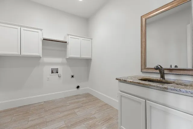 a kitchen with a sink cabinets and wooden floor
