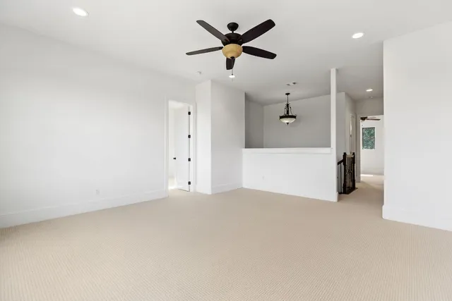 an empty room with ceiling fan and window