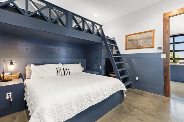 a bedroom with a bed a lamp and paintings on the wall