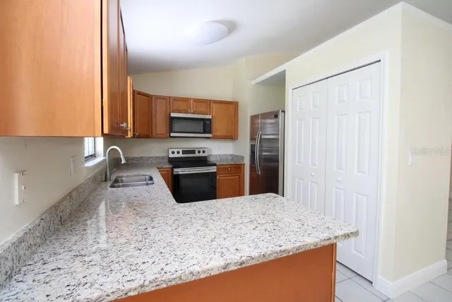 a kitchen with stainless steel appliances granite countertop a sink stove and refrigerator