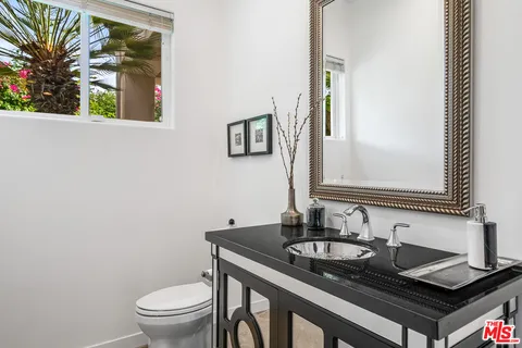 a bathroom with a granite countertop sink and a toilet