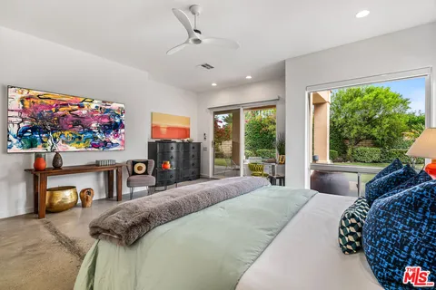 a spacious bedroom with a bed and wooden floor