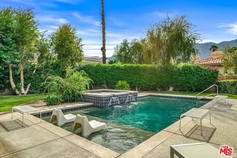 a bedroom with a bed and a table in it with potted plant
