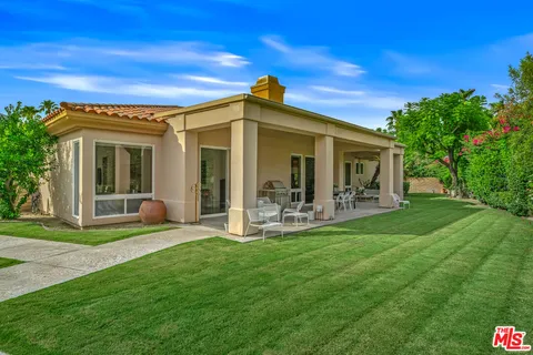 a front view of a house with a yard and potted plants
