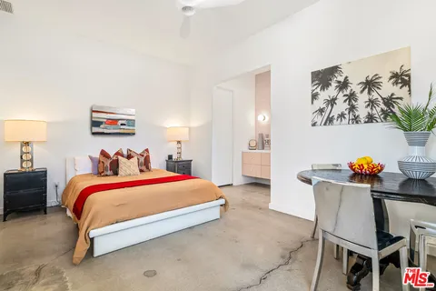 a view of swimming pool with lawn chairs and plants