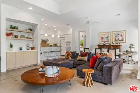 a living room with furniture kitchen view and a dining table