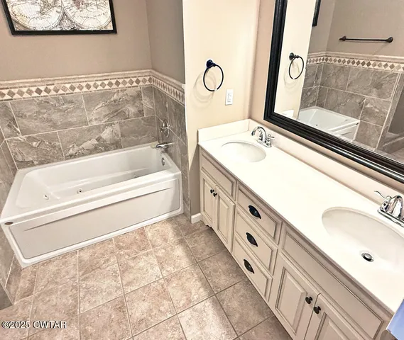 a bathroom with a tub sink and mirror