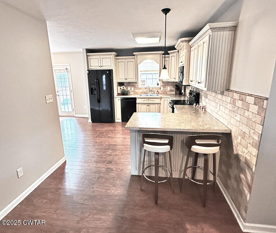 759 Timber Ridge Drive Lexington, TN 38351 - Photo 6 of 18 a kitchen with kitchen island a dining table chairs cabinets and refrigerator
