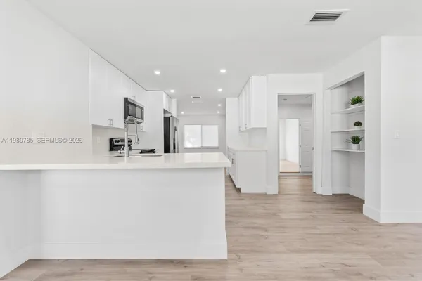 a view of kitchen with stainless steel appliances refrigerator sink and cabinets