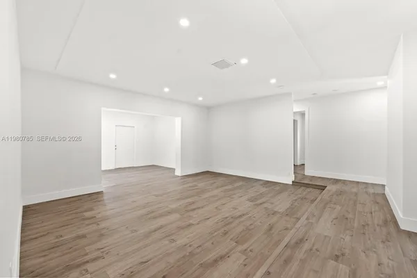 a view of an empty room with wooden floor