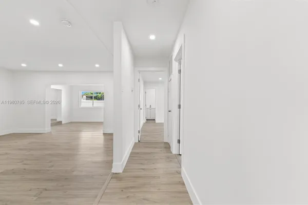 a view of a hallway with wooden floor