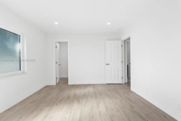 a view of an empty room with wooden floor