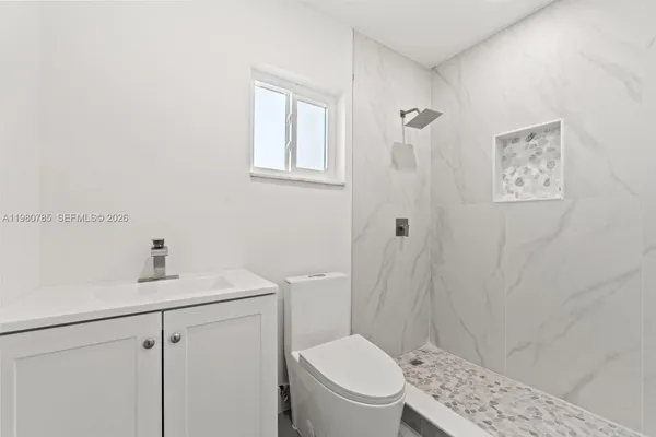 a white toilet sitting next to a bathroom sink