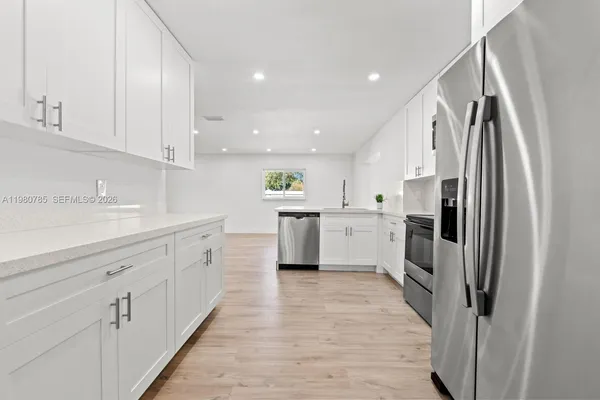 a kitchen with white cabinets and white appliances